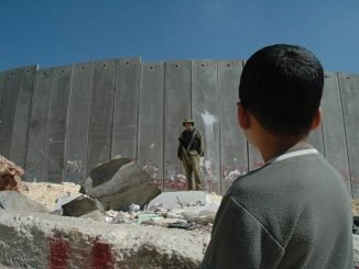 Boy and soldier at Israeli wall