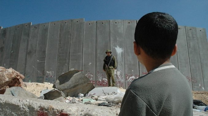 Boy and soldier at Israeli wall